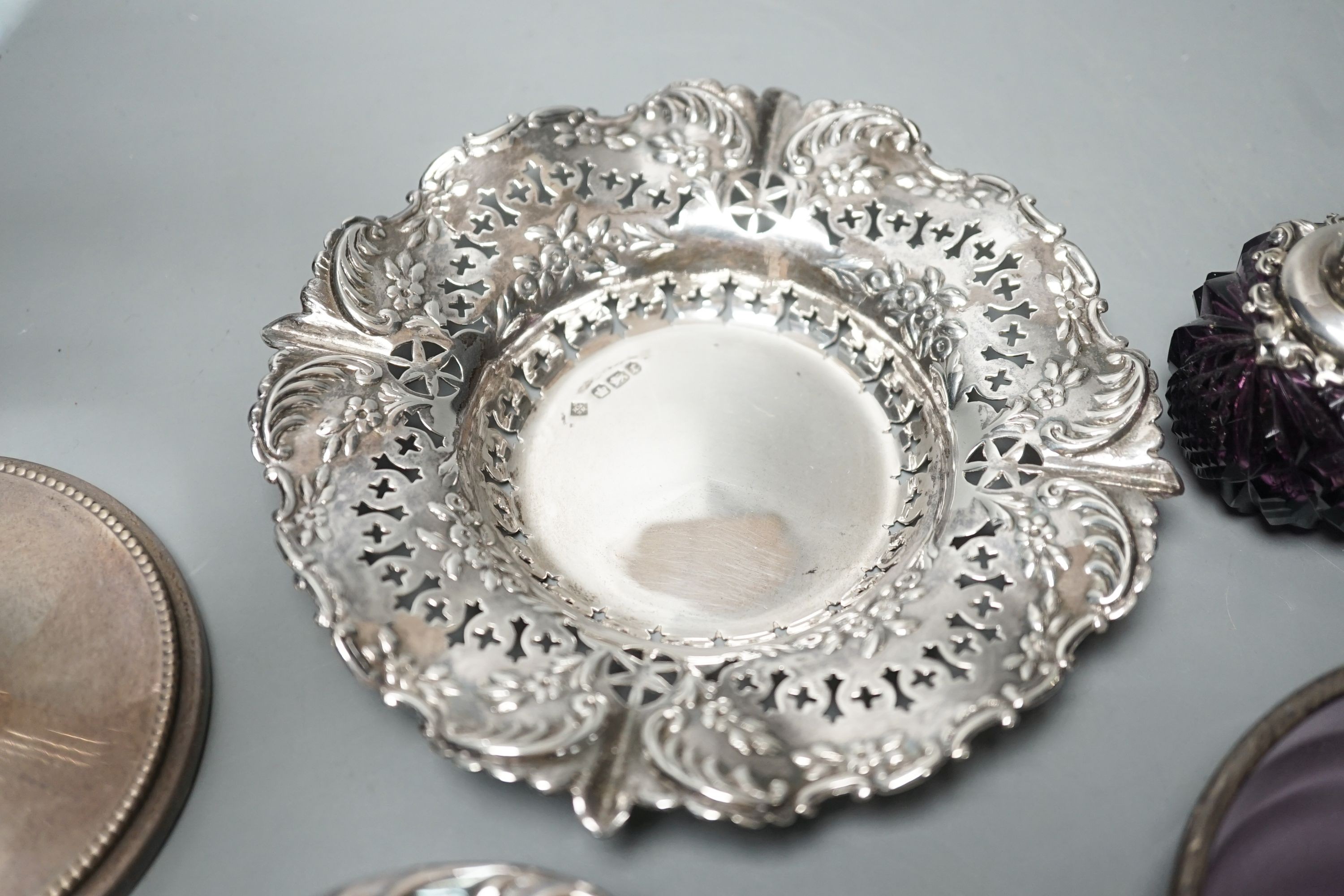 Two pierced silver trinket dishes, a late Victorian silver mounted amethyst glass dish, a similar scent flask and a silver mounted glass bowl.